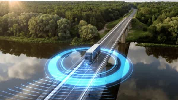 Self-Driving Vehicles autonomous truck using radar as it drives on a bridge overlooking a river