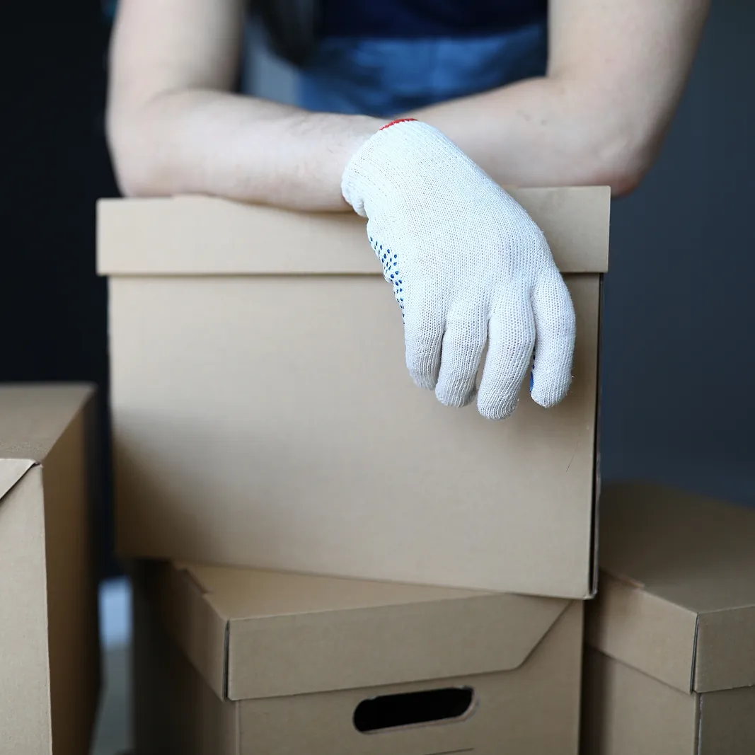 white glove shipping // guy with white gloves leaning over a shipping box