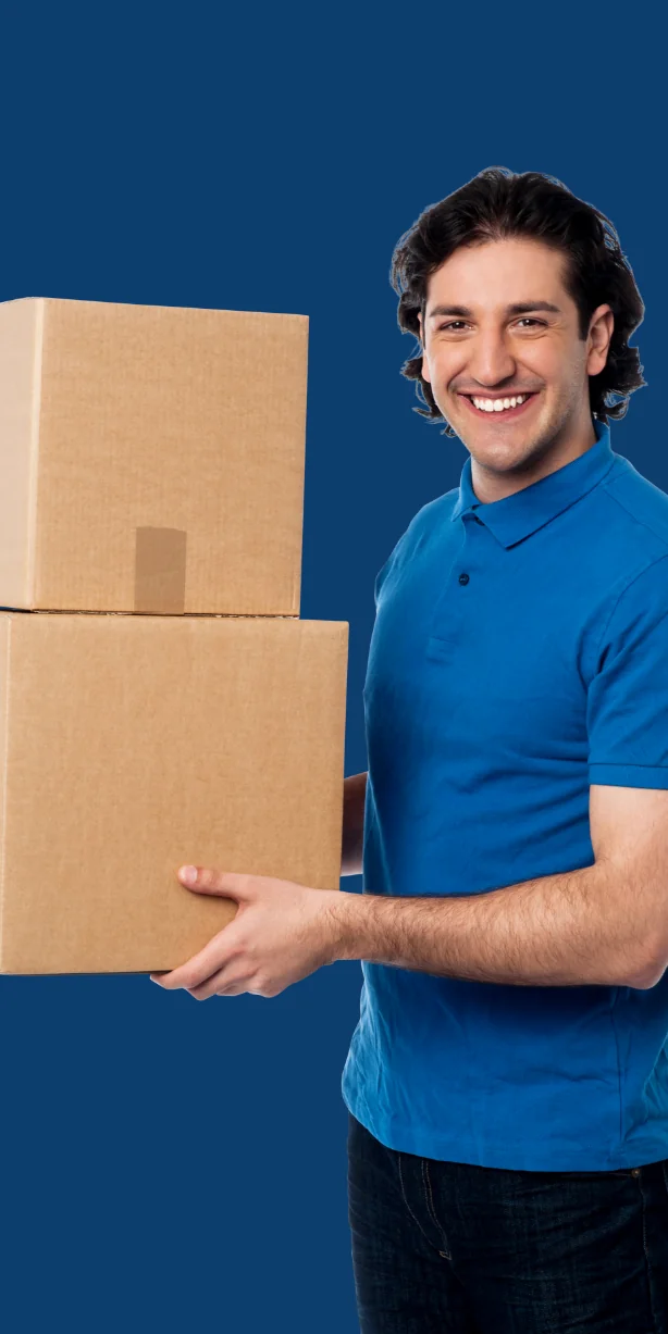 A gentlemen wearing a blue shirt holding two boxes and smiling