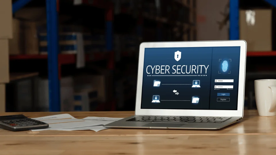 Cyber Attacks in the Transportation Industry laptop with cyber security program on it on top of table in warehouse