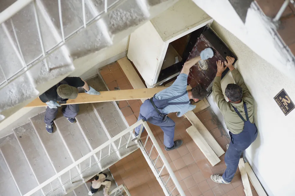 group of men uninstalling a large safe