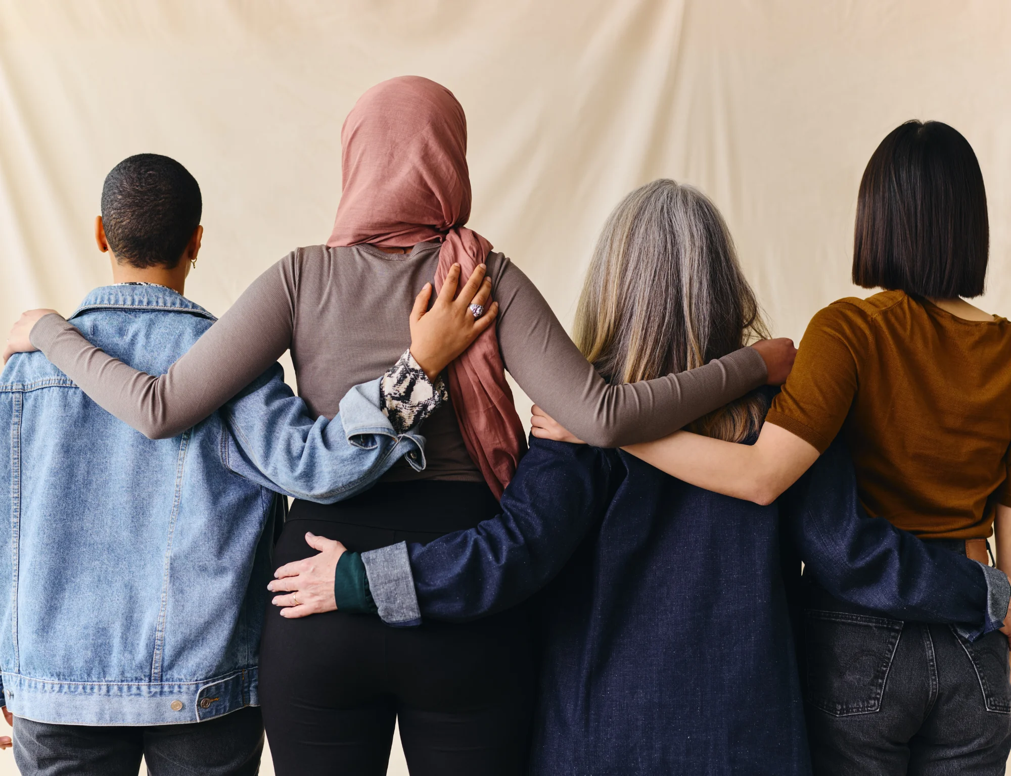 DEI policy-people-standing-side-by-side-with-arms-holding-each-other-facing-away