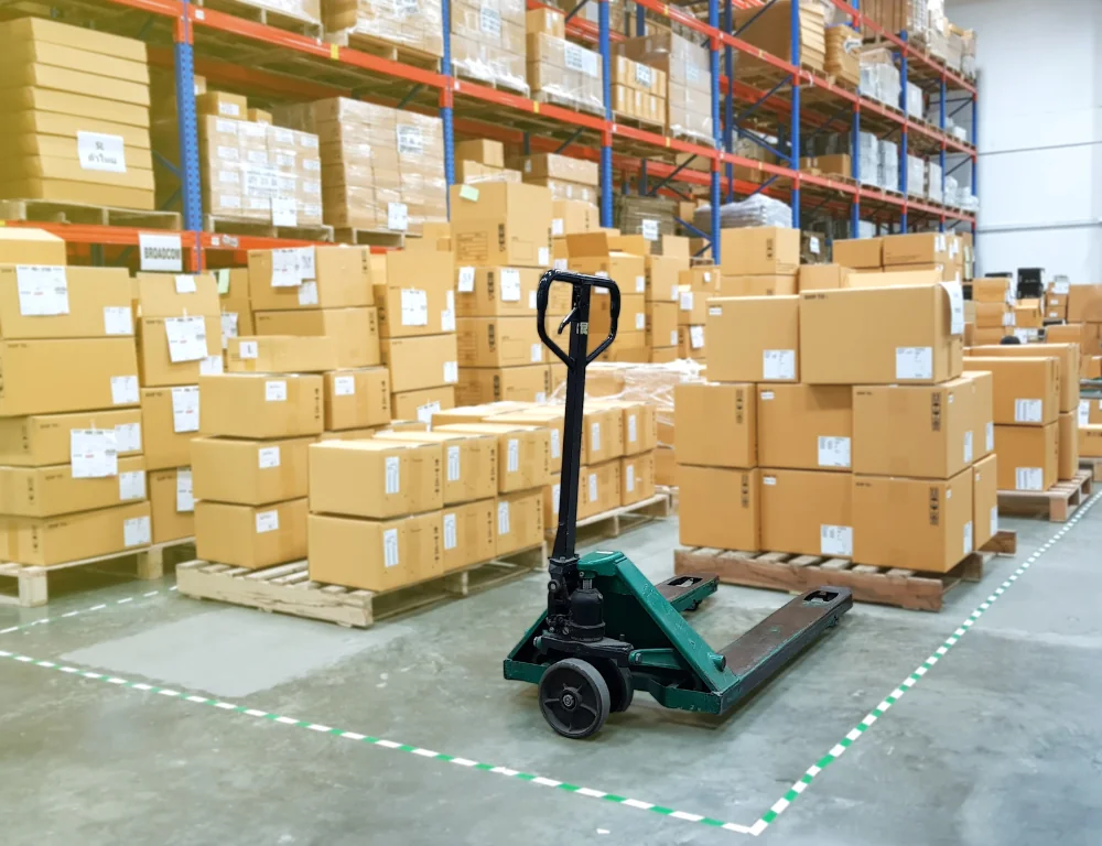 Shipping-Labels-pallet-jack-with-pallet-of-boxes-on-it-surrounded-by-other-palletized-boxes