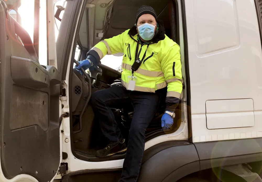 freight-shipping-during-coronavirus-truck-driver-wearing-mask-sitting-in-his-truck