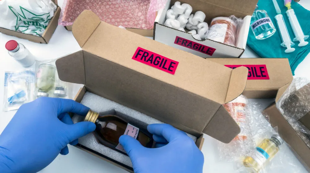 fragile glass bottle of medicine being packaged for shipping