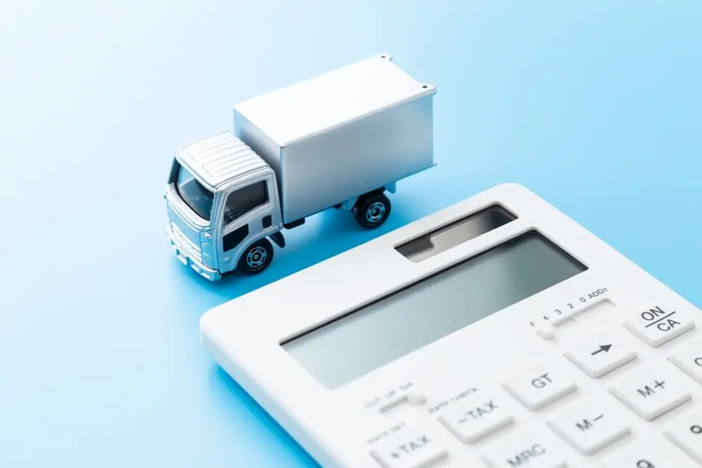 semi truck and calculator representing what is the cost of shipping