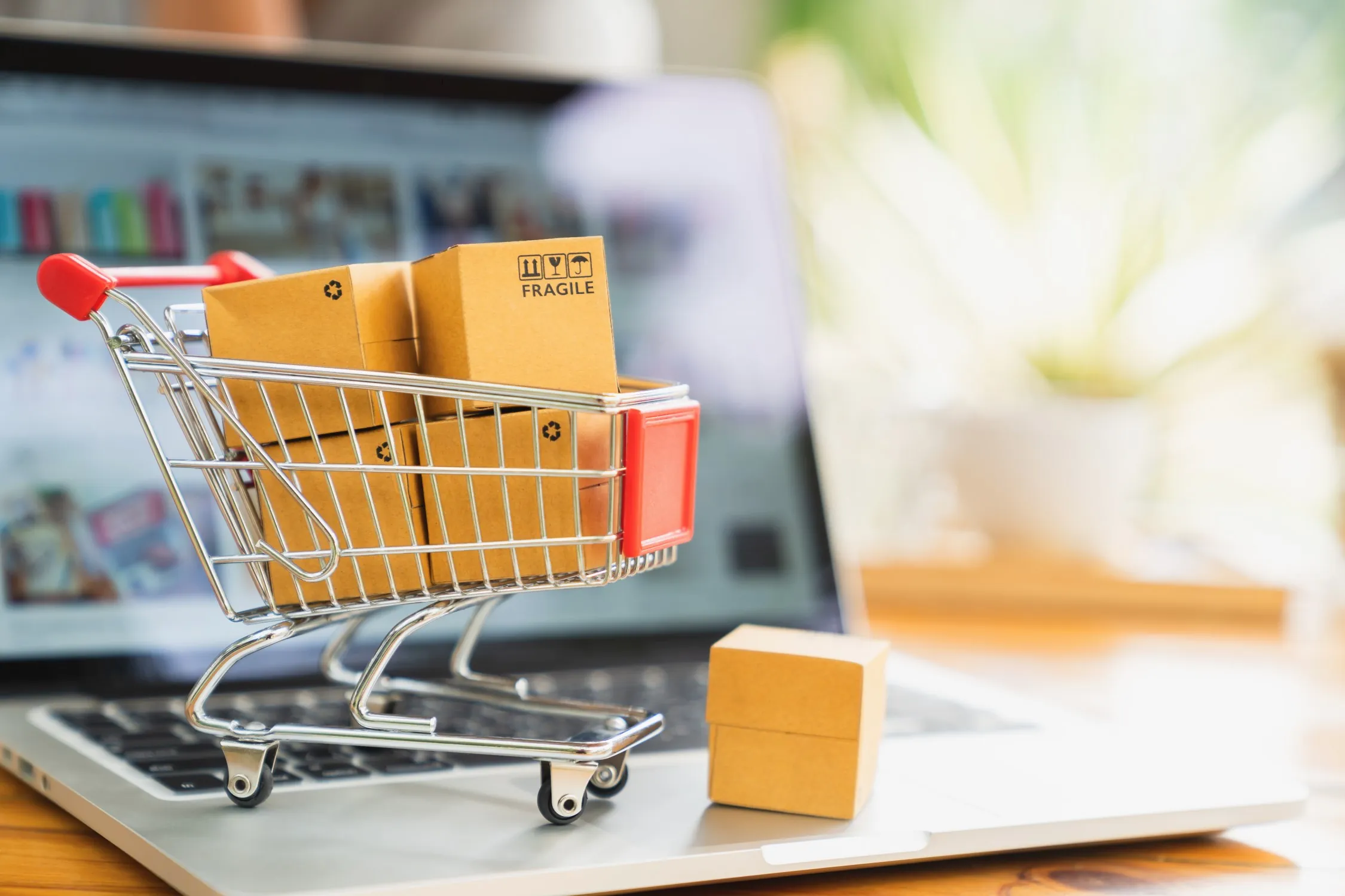 Impact Customer Loyalty shopping cart with packages in it on top of laptop