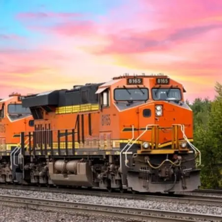 orange locomotive hauling rail freight