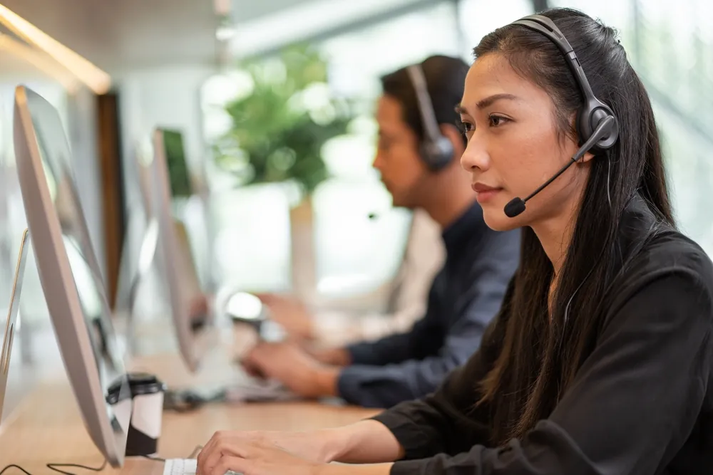 women with headset in front of a computer