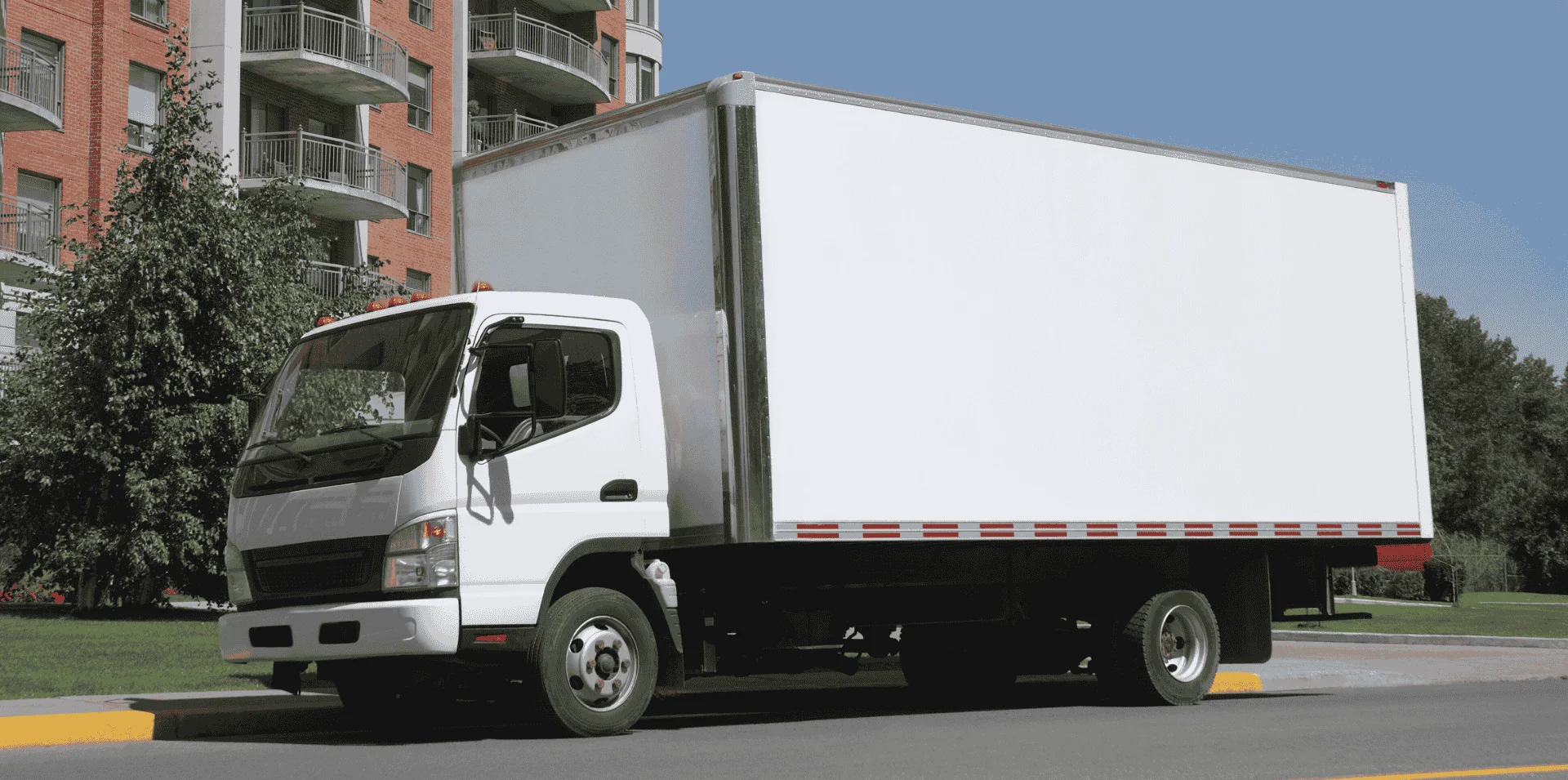 Straight truck white box truck parked in front of apartment building