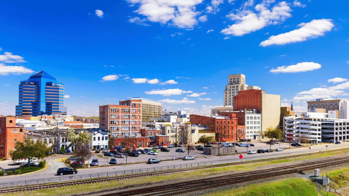 Durham Freight Shipping view of Durham cityscape with railroad in foreground during daytime