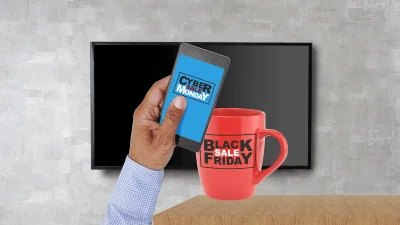 Black Friday Cyber Monday Logistics SMALL hand holding phone with CM ad on it and coffee mug with BF ad on it