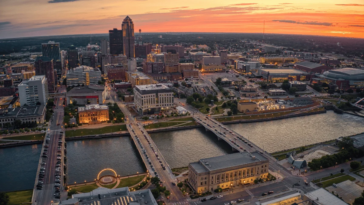 Des Moines Freight Shipping aerial view of Des Moines downtown with bridges crossing over river at sunset