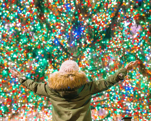 girl standing in front of rockefeller christmas tree