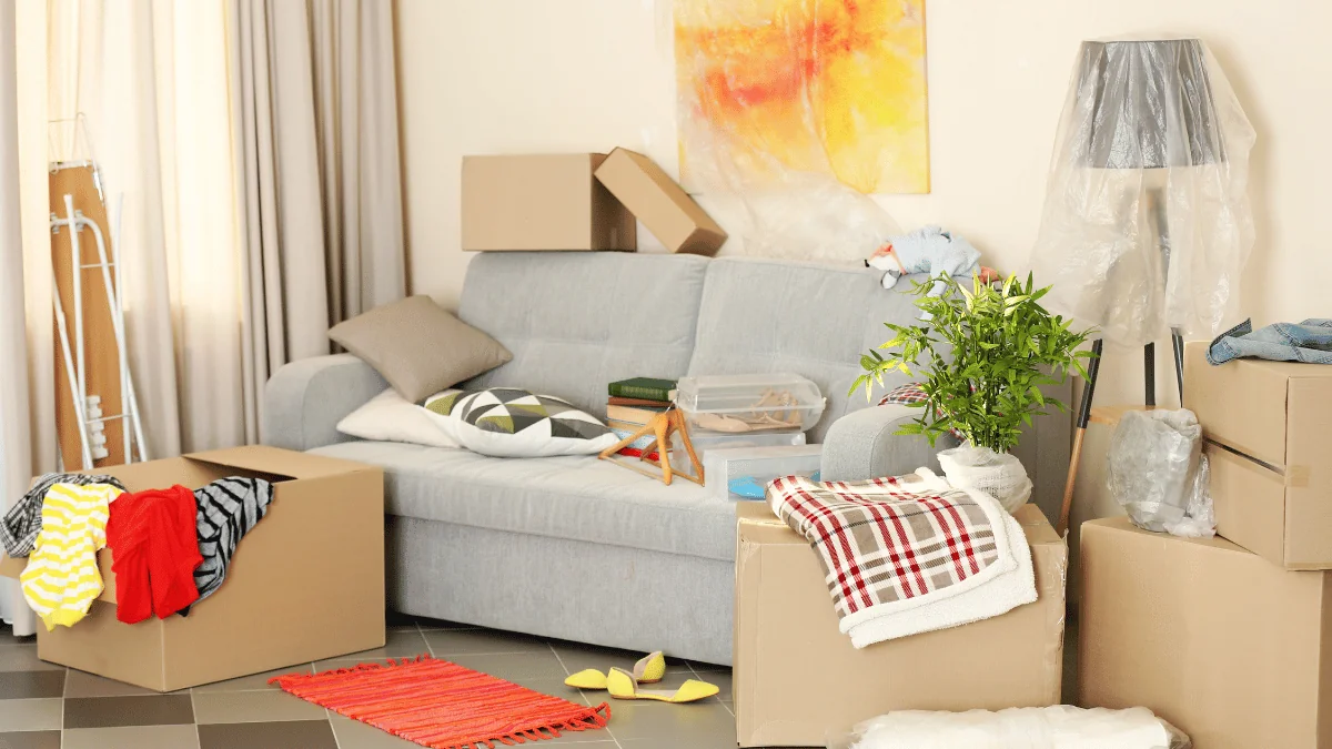 Shipping Household Goods grey couch with assorted household goods piled on and around it