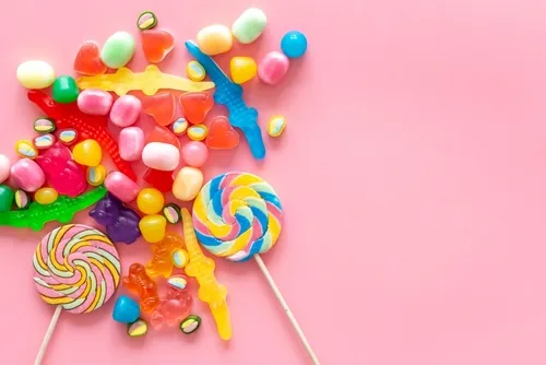 Different kinds of candy on pink background