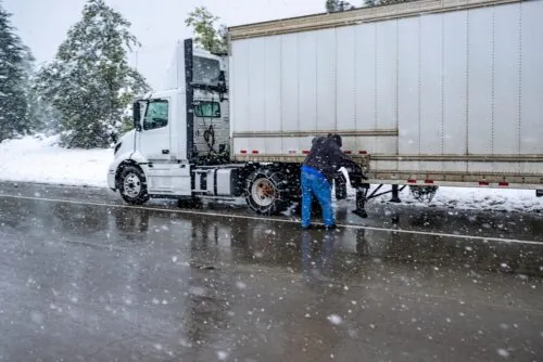 Trucker fixing truck in winter conditions