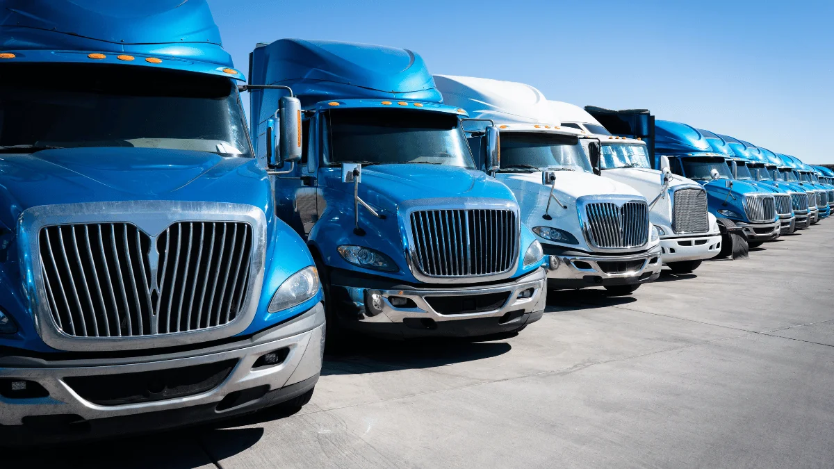 Dedicated Fleet Services blue semi trucks lined up diagonally