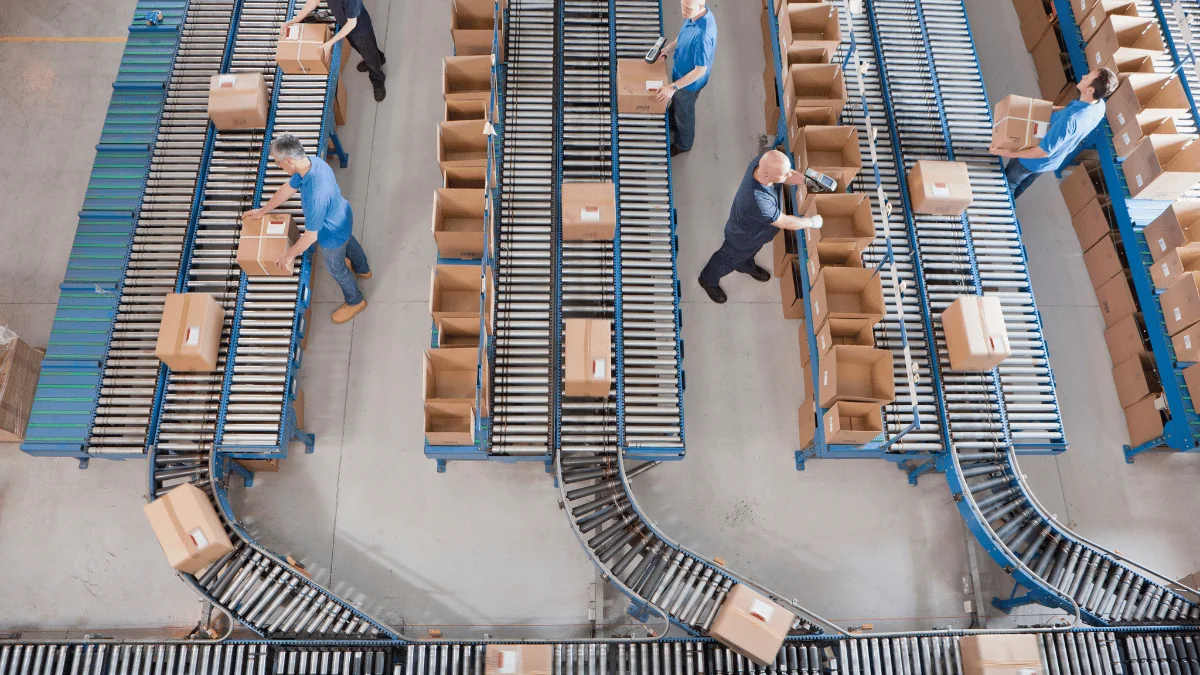 male employees scanning and packaging boxes on rolling conveyor belts