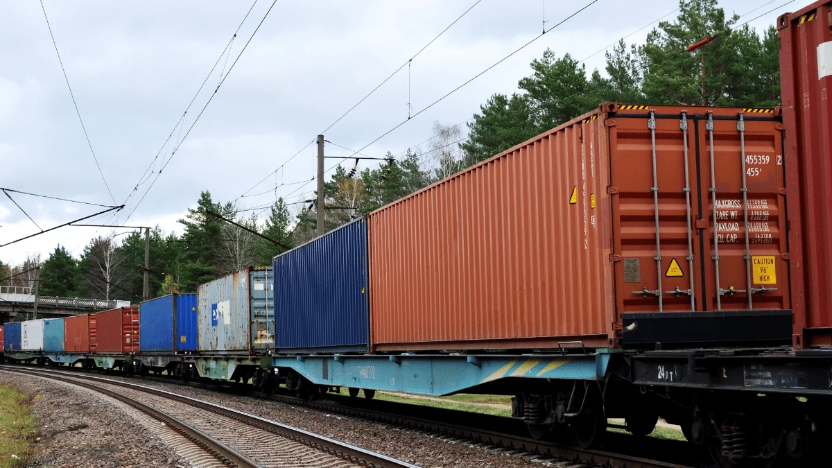 freight train with shipping containers loaded on driving down track