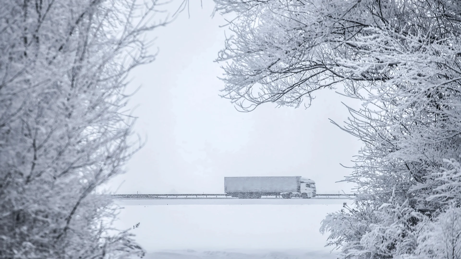 Winter Driving 15 Tips for Truckers semi truck driving down blizzardy highway in the distance