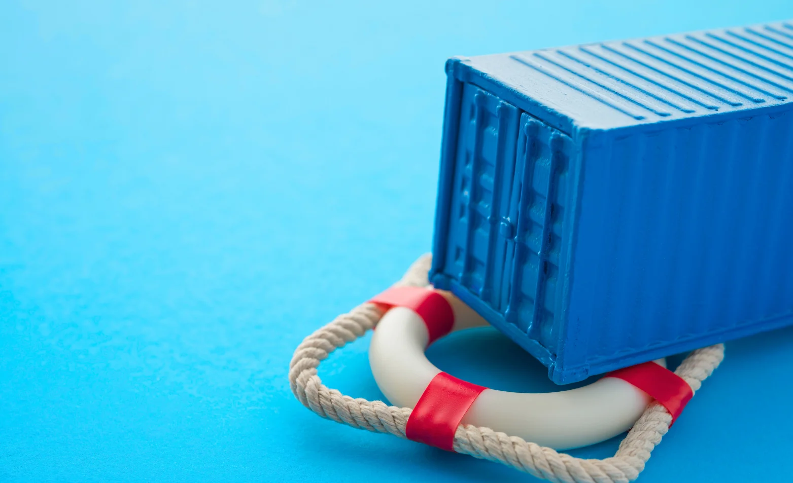 small toy blue container laying on a white and red flotation device