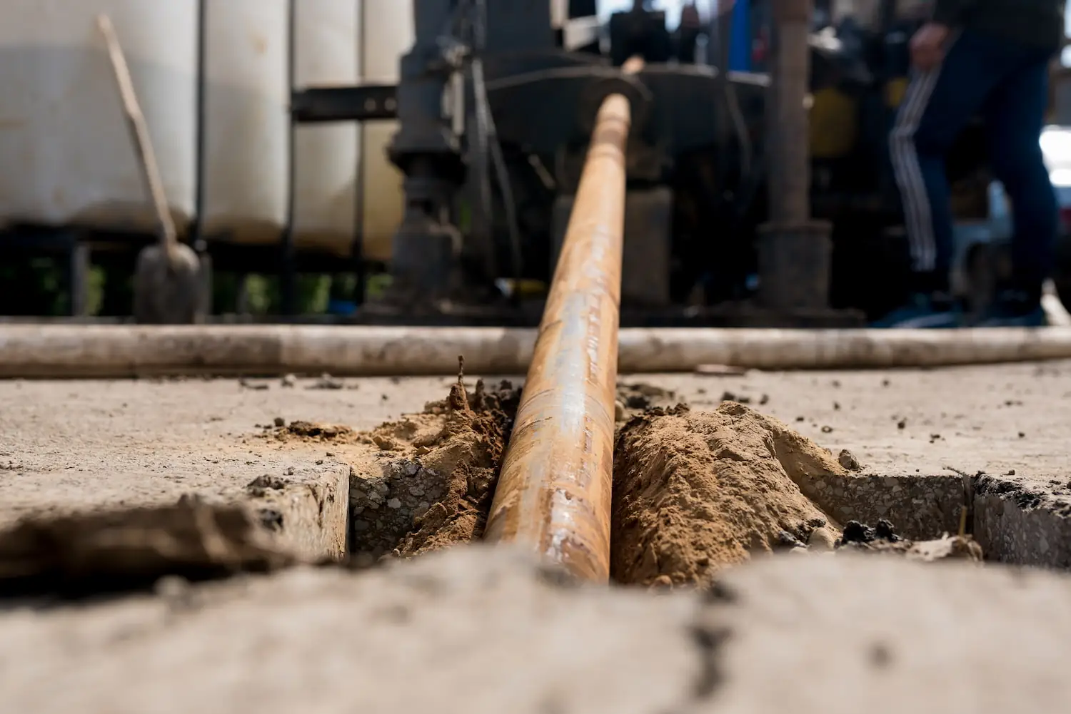 A horizontal directional drill going beneath the asphalt