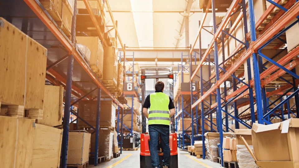 Shared Economy in Logistics warehouse worker operating forklift in warehouse aisle