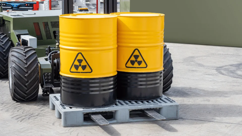 Shipping Chemicals and Hazardous Materials two yellow hazmat barrels on a pallet being lifted by forklift