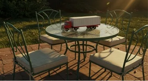 small model of a semi truck sitting on patio furniture outside