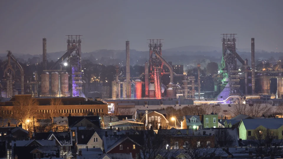 view of Bethlehem Steel smokestacks lit up at night during winter