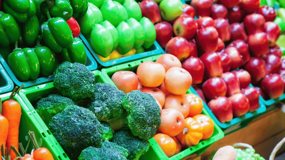 Shipping Agricultural Products rows of produce in green baskets in a supermarket aisle