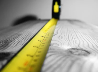 yellow tape measure on a plank of wood